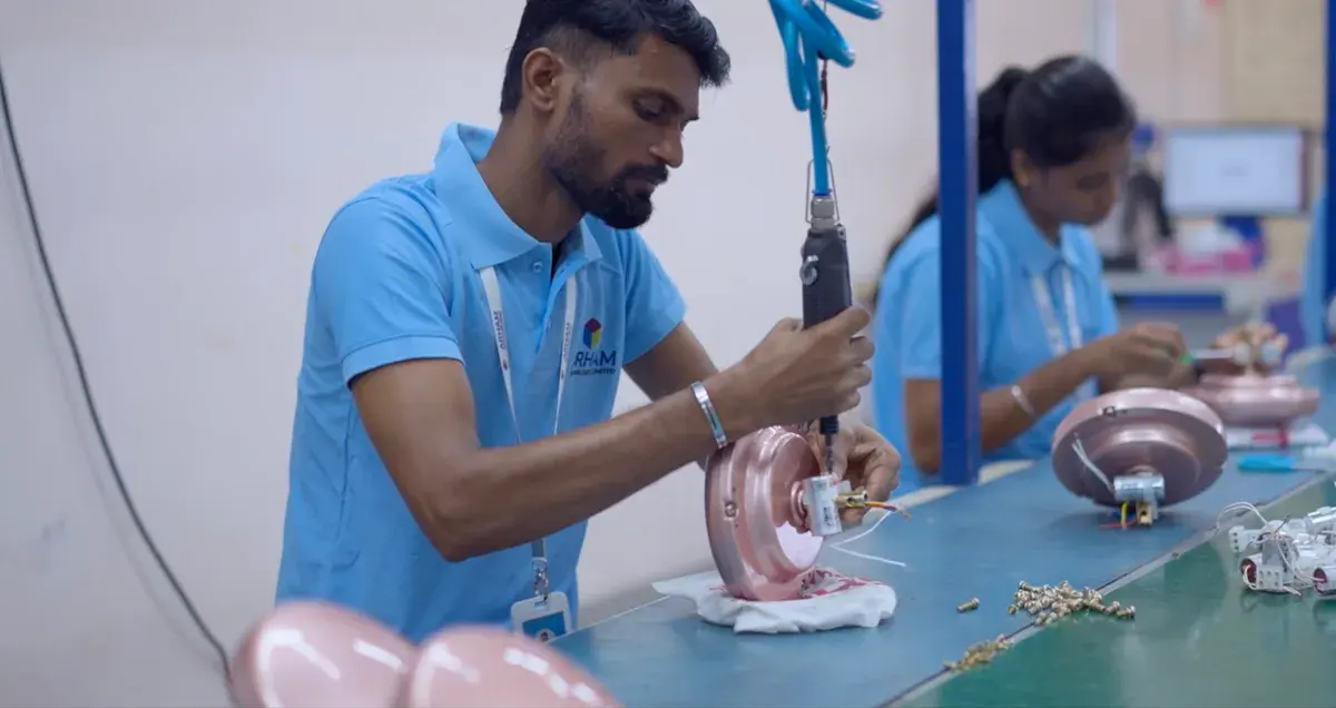 Arham team members assembling ceiling fan motors on the production line