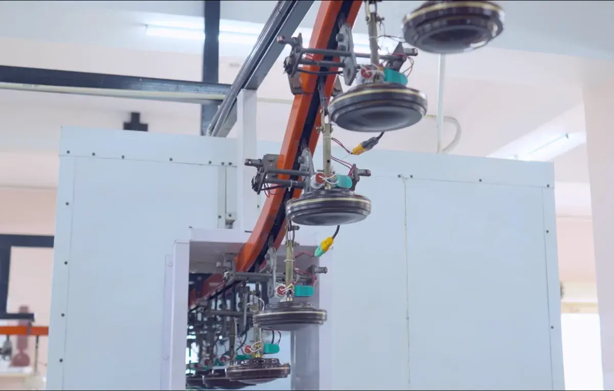 Ceiling fan motors moving along an overhead production conveyor